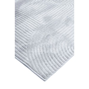 Zbliżenie na jasnoszary dywan z krótkim włosiem o geometrycznym wzorze.