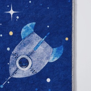 Niebieski dywan z motywem rakiety do pokoju dziecięcego.
