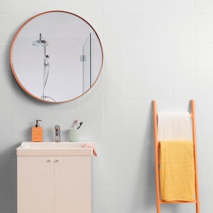 Łazienka z białymi płytkami ściennymi t.b.t., umywalką, lustrem i drabinką na ręczniki.