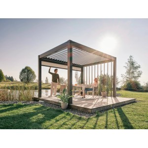 Pergola Biohort w kolorze ciemnoszarym/srebrnym metalik z ludźmi na drewnianym tarasie w ogrodzie.