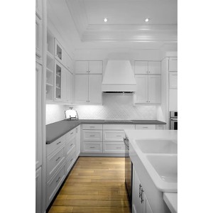 Jasna kuchnia z białymi szafkami, okapem i drewnianą podłogą. Elementy dekoracyjne.