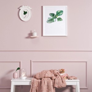 Różowa dekoracja ścienna z elementami dekoracyjnymi i tekstyliami. Kolorowa farba do ścian dla przytulnej atmosfery.