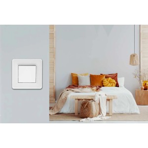 Białe ramki t.b.t. do włączników i gniazdek na ścianie w sypialni.