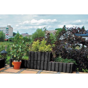 Szare palisady t.b.t. jako obrzeże rabat kwiatowych w ogrodzie.