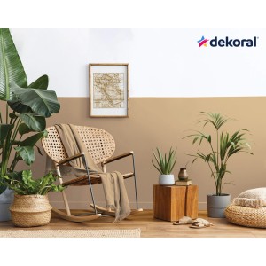 Pokój dzienny z brązową i białą farbą na ścianach, fotelem i roślinami. Dekoracyjny pomysł na aranżację.