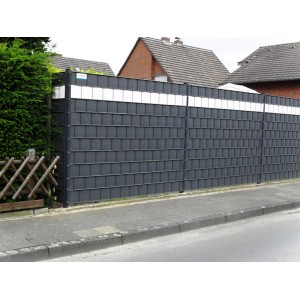 Szara mata ogrodzeniowa t.b.t. z białymi akcentami zapewniająca prywatność w ogrodzie.