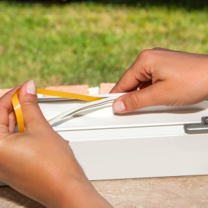 Naklejanie taśmy uszczelniającej na ramę okienną. Akcesoria okienne.