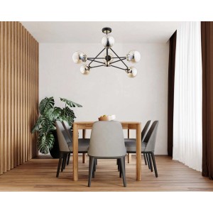Nowoczesna lampa wisząca t.b.t. z sześcioma szklanymi kulami i czarną ramą nad stołem jadalnym.