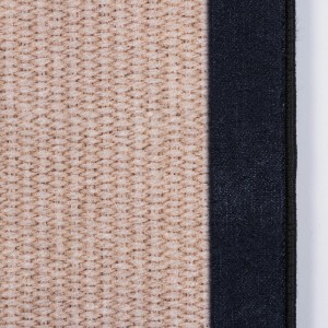 Zbliżenie dywanu z krótkim włosiem o beżowym wzorze i ciemnym obramowaniu.