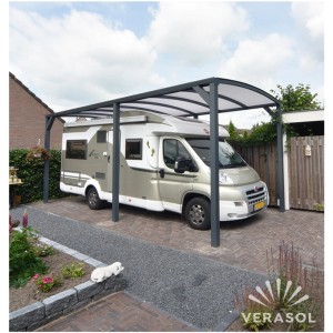 Szary garaż t.b.t. z kamperem. Carport zapewnia ochronę przed warunkami atmosferycznymi.