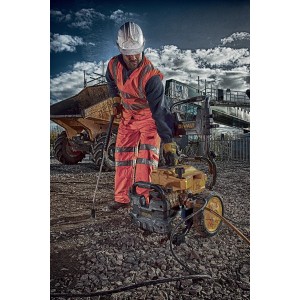 Myjka wysokociśnieniowa DeWalt DXPW004E w użyciu na placu budowy z robotnikiem budowlanym.