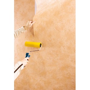 Użytkownik dociska tapetę wałkiem do szwów LUX (18 cm). Narzędzie do tapetowania z wałkiem z gumy piankowej.