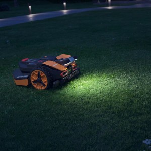 Robot koszący Worx Landroid Vision z reflektorem LED w użyciu w nocy.