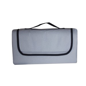 Złożony szary koc kempingowy t.b.t. z uchwytem.