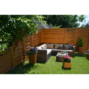 Drewniane ogrodzenie t.b.t. w ogrodzie z meblami wypoczynkowymi i skrzynkami na kwiaty.