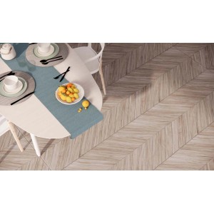 Płytki podłogowe t.b.t. imitujące drewno, ułożone w jodełkę pod stołem.