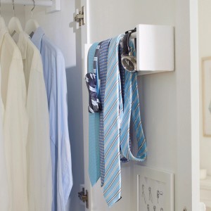 Wieszak na krawaty w szafie z krawatami i zegarkiem.