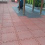 Czerwone, łączone płytki na plac zabaw dla bezpiecznej ochrony przed upadkami podczas zabawy na świeżym powietrzu.