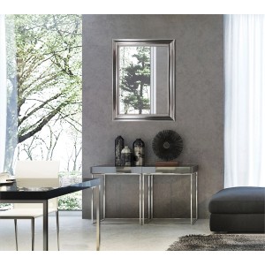 Prostokątne lustro do garderoby t.b.t. ze srebrną ramą na szarej ścianie.