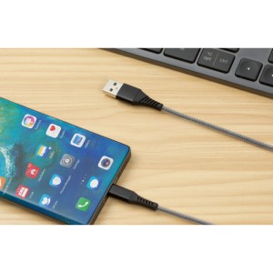 Czarny kabel USB do ładowania (USB-A do USB-C) ze smartfonem i klawiaturą w tle.