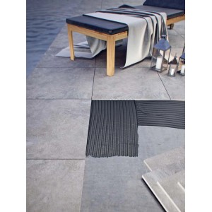 Układanie szarych płytek podłogowych na zewnątrz. Szczegółowy widok z warstwą kleju.