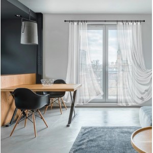 Klasyczny czarny karnisz z białymi zasłonami w nowoczesnym salonie.