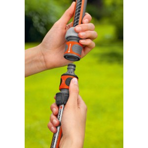 Złączka Gardena w dłoni do łączenia dwóch węży ogrodowych.