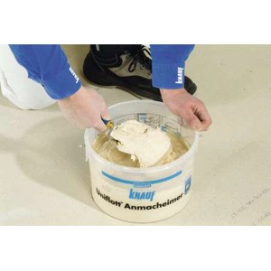 Użytkownik miesza masę szpachlową Knauf Uniflott w wiadrze. Idealna do płyt gipsowych wewnątrz.