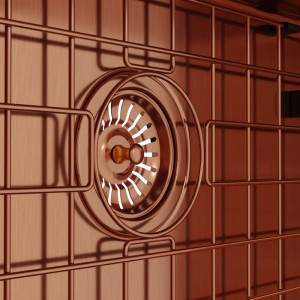 Zbliżenie na zlew ze stali nierdzewnej z koszyczkiem sitkowym w kolorze miedzi.