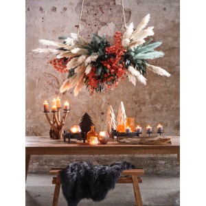 Dekoracyjna kompozycja z trawy pampasowej ze świecami i elementami dekoracyjnymi na drewnianym stole.