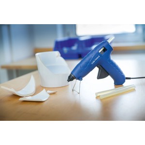 Zestaw pistoletu do kleju na gorąco LUX 100W z wkładami klejowymi i rozbitym przedmiotem ceramicznym na stole.