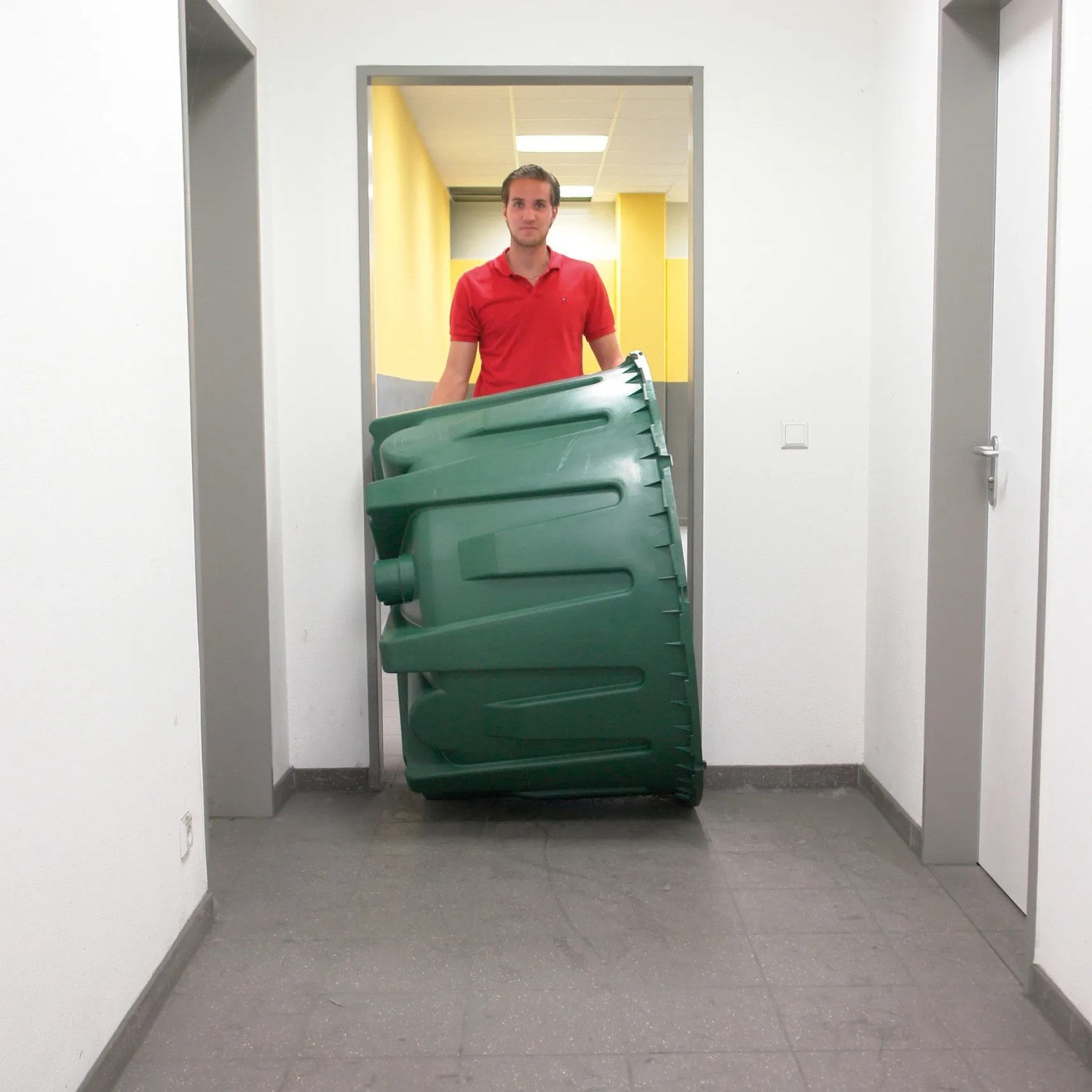 Zielona cysterna Garantia Herkules 1600 l transportowana przez korytarz.
