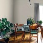 Pokój dzienny z kolorowo pomalowaną ścianą, stołem i roślinami doniczkowymi. Kolorowa farba do ścian wewnętrznych.