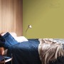 Sypialnia z oliwkowozieloną farbą na ścianie. Kolorowa farba do ścian dla przytulnej atmosfery.