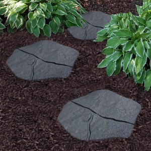 Trzy szare podesty t.b.t. w ogrodzie między roślinami i korą.