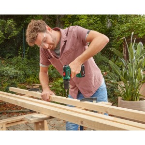 Akumulatorowa wiertarko-wkrętarka udarowa Bosch EasyImpact 18V-40 podczas wiercenia w drewnie.