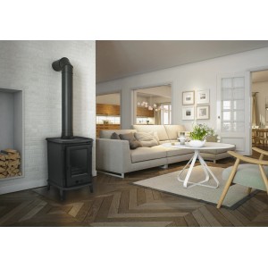 Czarny piec w salonie z sofą i drewnianą podłogą.