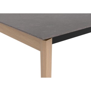 Zbliżenie stołu ogrodowego z szarym blatem i jasną drewnianą ramą.