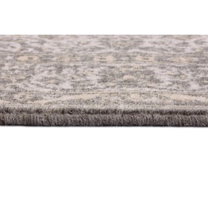 Zbliżenie dywanu z krótkim włosiem t.b.t. ze wzorem w kolorze szarym.