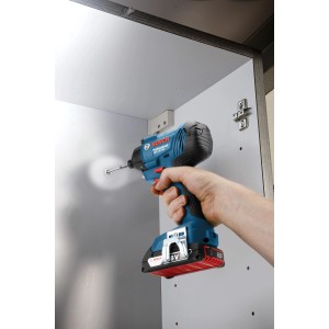 Akumulatorowy klucz udarowy Bosch Professional GDR 18V-160 C Solo wkręca śrubę w szafkę.