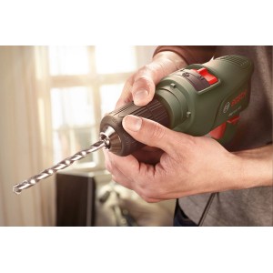 Zielona wiertarka z wiertłem w dłoniach. Kategoria: Wiertarki.