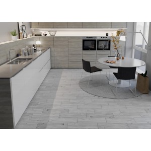 Jasne płytki podłogowe t.b.t. imitujące drewno ułożone w nowoczesnej kuchni.