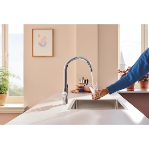 Zestaw baterii kuchennej Grohe Blue Pure Start Curve z filtrem węglowym napełniający szklankę.