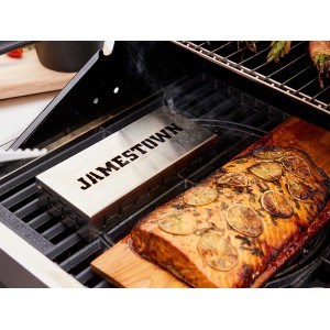 Pojemnik do wędzenia Jamestown ze stali nierdzewnej na grillu z łososiem na desce drewnianej. Akcesorium do grilla dla wędzonego smaku.