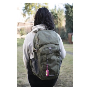 Osoba z oliwkowozielonym plecakiem, do którego przymocowana jest mała, różowa latarka t.b.t.