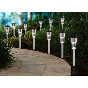 Kilka srebrnych solarnych lamp ścieżkowych w ogrodzie. Dekoracyjne oświetlenie zewnętrzne.