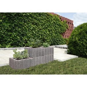 Szare kamienie roślinne t.b.t. jako obrzeże rabaty w ogrodzie.