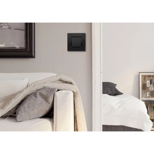 Czarny włącznik t.b.t. na szarej ścianie w salonie.