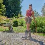 Kobieta podlewa ogród wężem ogrodowym. Kategoria: Węże ogrodowe.