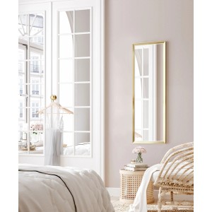 Prostokątne lustro do garderoby t.b.t. ze złotą ramą w sypialni.